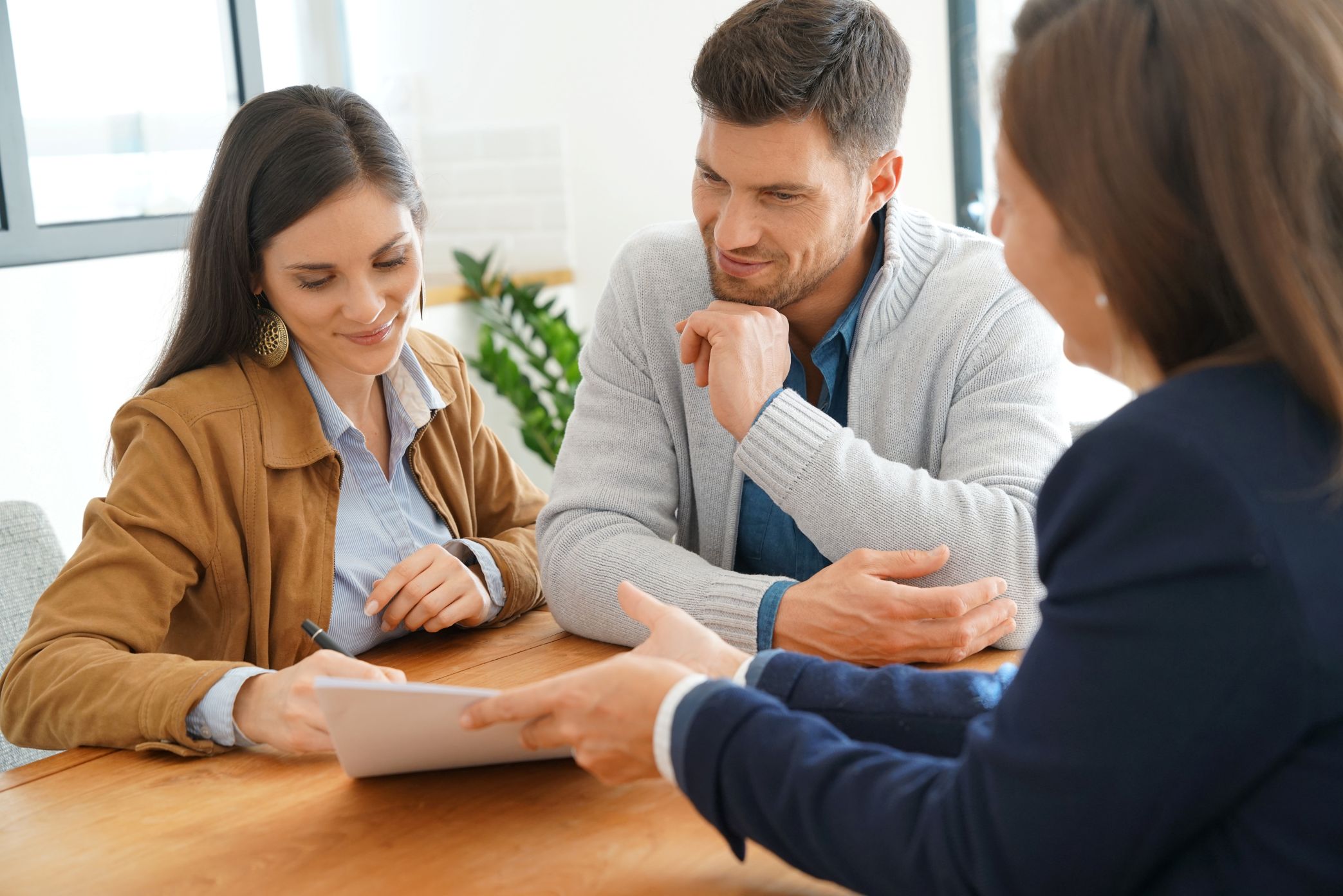Couple signs documents at meeting with financial planner about special needs planning.